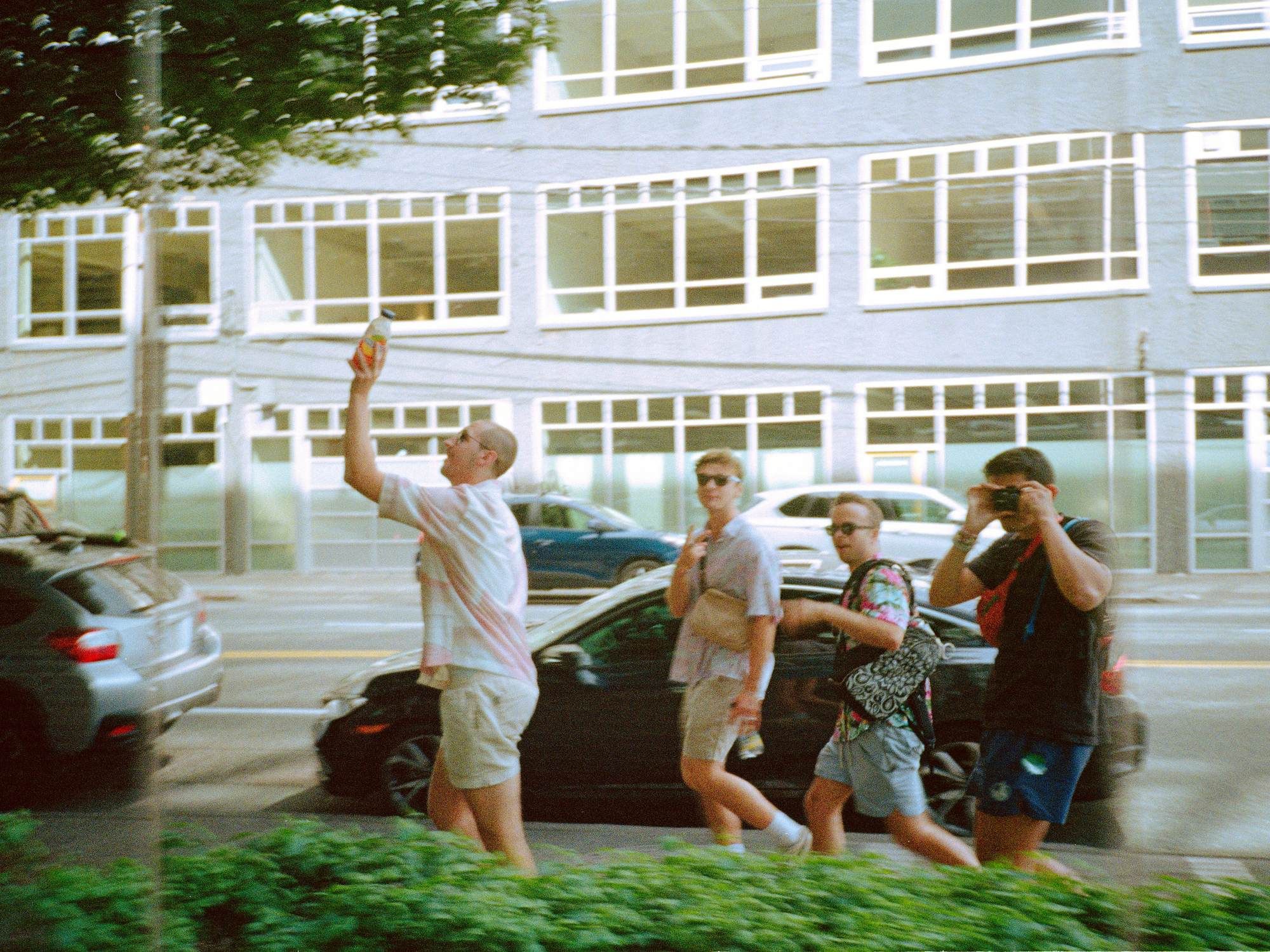 Students walking together on a sidewalk in front of a modern building at VERVE Fayetteville.